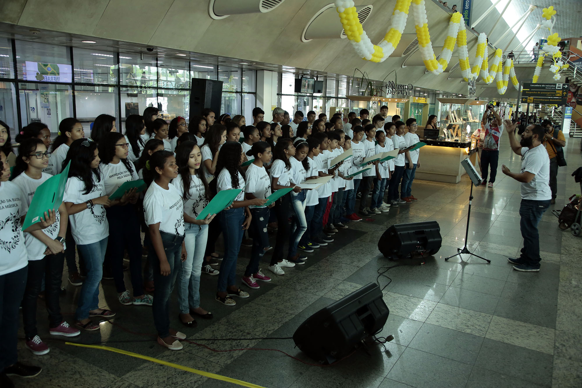 Estudantes recepcionam turistas com música no aeroporto de Belém