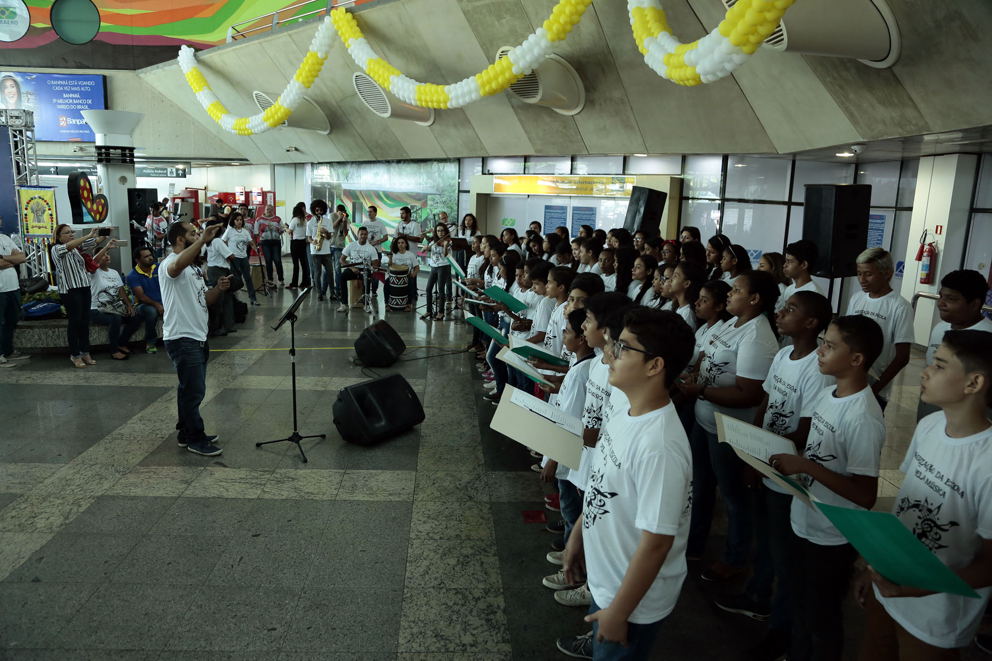Estudantes recepcionam turistas com música no aeroporto de Belém